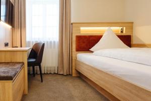 Cette chambre comprend un lit et un bureau. dans l'établissement Hotel Sixt, à Rohr