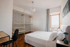 a bedroom with a bed and a desk and a window at Casa Rufino, Sauna e Cromoterapia in Assisi
