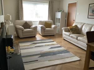 a living room with two couches and a rug at Carrick House, Mid-Ulster in Knockcloghrim