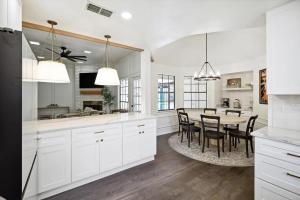 a kitchen with white cabinets and a table with chairs at Allen Abode - 4 Bedrm Pool Fire Pit Charm in Allen