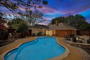 a swimming pool in front of a house at Allen Abode - 4 Bedrm Pool Fire Pit Charm in Allen