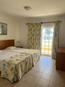 1 dormitorio con cama y ventana grande en Albufeira Marina Villa, en Albufeira