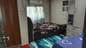 a small bedroom with a bed and a window at Kubang Sepat HomeStay in Ayer Hitam