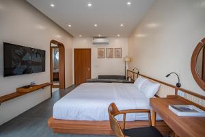 a bedroom with a large white bed and a desk at Spacious 6BR Villa Near Beach in Ha Long