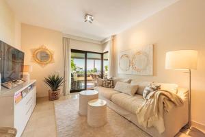 ein Wohnzimmer mit einem Sofa und einem TV in der Unterkunft Resort Marbella Pools Family Golf Wifi Children in Estepona