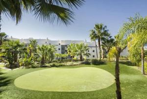 einen Golfplatz mit Palmen vor einem Gebäude in der Unterkunft Resort Marbella Pools Family Golf Wifi Children in Estepona