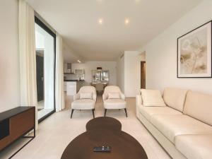- un salon avec un canapé blanc et des chaises dans l'établissement Duplex 3 Bedrooms Wifi Pools Jacuzzi, à Estepona