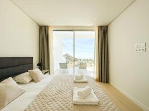 1 dormitorio con 1 cama grande y 2 toallas. en Luxury Palo Alto Apartment Ocean Views Marbella, en Marbella