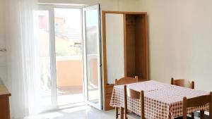 una sala da pranzo con tavolo e porta scorrevole in vetro di One bedroom apartement with sea view enclosed garden and wifi at Razanac a Ražanac (Rasanze)