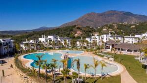 - une vue aérienne sur un complexe avec une piscine et des palmiers dans l'établissement New luxury apartment in family resort w pools wifi, à Estepona