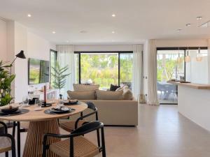- un salon avec une table et un canapé dans l'établissement New luxury apartment in family resort w pools wifi, à Estepona