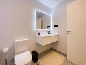 La salle de bains est pourvue de toilettes blanches et d'un lavabo. dans l'établissement New luxury apartment in family resort w pools wifi, à Estepona