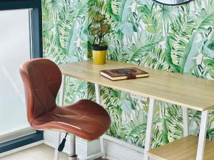 uma cadeira sentada ao lado de uma mesa com um papel de parede em Stylish, modern appartment in Central London em Londres