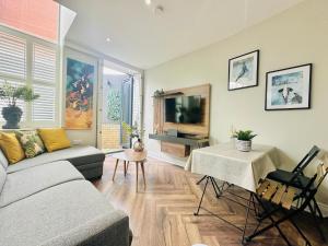 ロンドンにあるStylish, modern appartment in Central Londonのリビングルーム(ソファ、テレビ付)