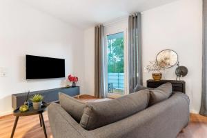 ein Wohnzimmer mit einem Sofa und einem TV in der Unterkunft Km Style Apartments 8 in Freiburg im Breisgau