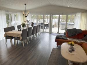 a living room with a table and chairs and a dining room at Large villa with SPA and lake view outside Hultsfred in Vena