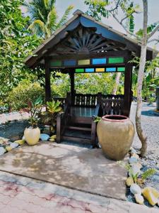 a small gazebo with a vase in front of it at Kubang Sepat HomeStay in Ayer Hitam
