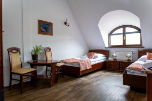 a room with two beds and a table and chairs at NOVA.Galicja in Nowy Sącz +68 photos