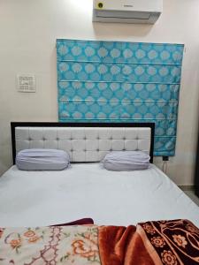 a bedroom with a white bed with a blue wall at Goroomgo Gautam Garden Varanasi in Varanasi