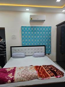 - une chambre avec un grand lit et un mur bleu dans l'établissement Goroomgo Gautam Garden Varanasi, à Varanasi