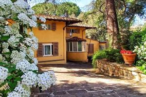 una casa gialla con fiori bianchi di fronte di Park Palace Hotel a Firenze