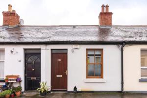 a white house with brown doors and windows at Central Location 2 BEDROOM 2 BATHROOM FAST WIFI in Dublin