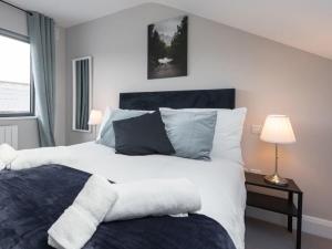 Un dormitorio con una gran cama blanca y una ventana en LOVELY 2bed HOME with patio & fast reliable WIFI, en Dublín