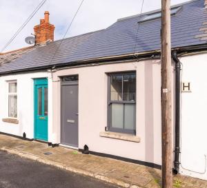 a white building with a blue door and windows at LOVELY 2bed HOME with patio & fast reliable WIFI in Dublin
