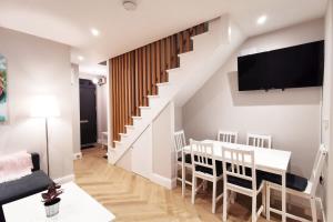 un comedor con mesa y sillas y una escalera en LOVELY 2bed HOME with patio & fast reliable WIFI, en Dublín