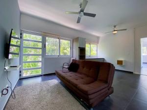 un soggiorno con divano marrone e ventilatore a soffitto di Big 5BR Home for an epic time in Riviera Maya ad Akumal