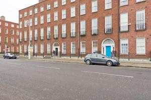 a car parked in front of a large brick building at CENTRAL LOCATION 2 BED APT Fast WIFI & TV&KITCHEN in Dublin