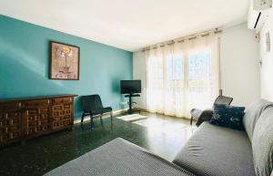 a living room with blue walls and a couch and chairs at Book Mercurio Salou in Salou