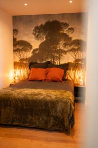 a bedroom with a bed with a painting on the wall at Appartements plein centre, à 5 minutes du château in Onzain