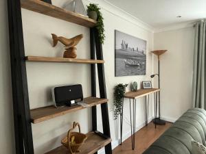 a living room with wooden shelves on the wall at Craster Crew Quarters in Craster