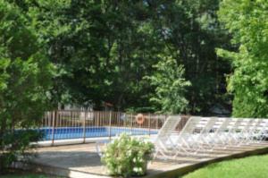 a white bench in front of a swimming pool at 2 River Road Inn Cottages in Cape Neddick