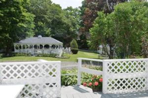 a white fence with a gazebo in a garden at 2 River Road Inn Cottages in Cape Neddick