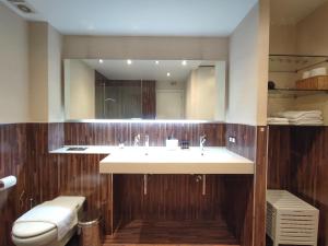 a bathroom with a sink and a mirror at DFLAT Escultor Madrid Apartments in Madrid