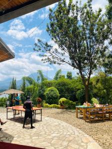 eine Person, die an einem Tisch in einem Garten steht in der Unterkunft Ruhondo Beach Resort in Ruhengeri