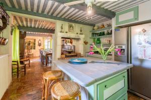 una cucina con bancone e sedie in camera di La Tuilerie a Saint-Rémy-de-Provence