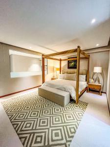 a bedroom with a canopy bed and a rug at Spectacular Ocean front 5BR condo in Bolongo in Punta Mita +28 photos