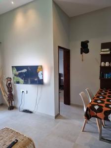 a dining room with a table and a television on the wall at Aqua view Apartments in Bijilo