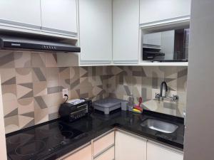 a kitchen with white cabinets and a sink at Flat- mercure c/ quarto, sala e coz - Moema in São Paulo