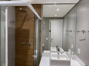 a bathroom with two sinks and a shower at Flat- mercure c/ quarto, sala e coz - Moema in São Paulo