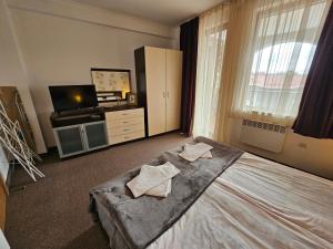 a bedroom with a bed with two towels on it at Viva 5 apartment Grand Monastery on the ski slopes in Pamporovo