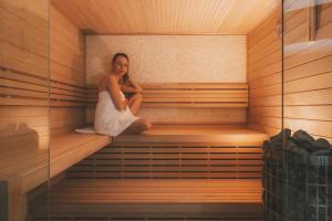 een vrouw zit in een sauna bij Villa Matylda in Mariánské Lázně