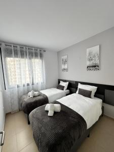 a bedroom with two beds and a window at Luxurious, Newly-Renovated Large 2-Bedroom Condo by the Beach in Benidorm