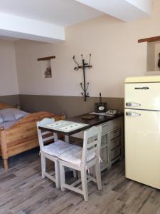a kitchen with a table and a refrigerator and a bed at Chambres d'hôtes d'Albertine in Lere