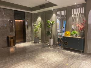 a lobby with potted plants in a building at Dm kara Rus Hotel - Muslim Street Branch in Xi'an
