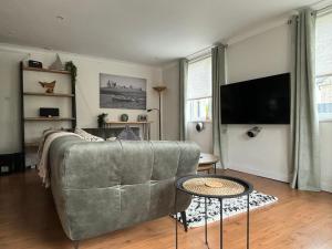 a living room with a couch and a flat screen tv at Craster Crew Quarters in Craster