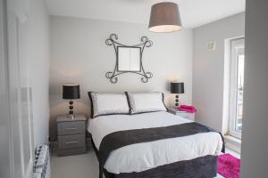 a bedroom with a bed with a black and white comforter at Connemara Letting's Townhouse in Clifden